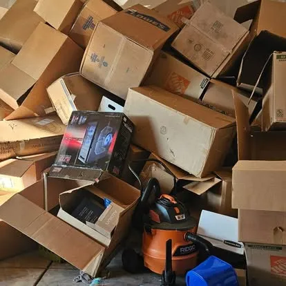 Garage piled high with flattened and stacked cardboard moving boxes around a Shop-Vac