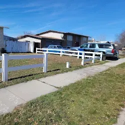 Same yard after cleanup with the white vinyl fence intact and grass clear