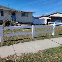 Front view of the property after cleanup with restored fence and tidy yard