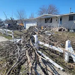 Closer view of the storm debris stacked along the fence line